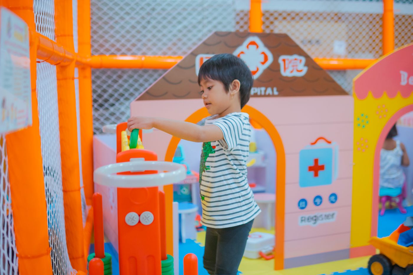 Child happily playing in a bright, colorful play space